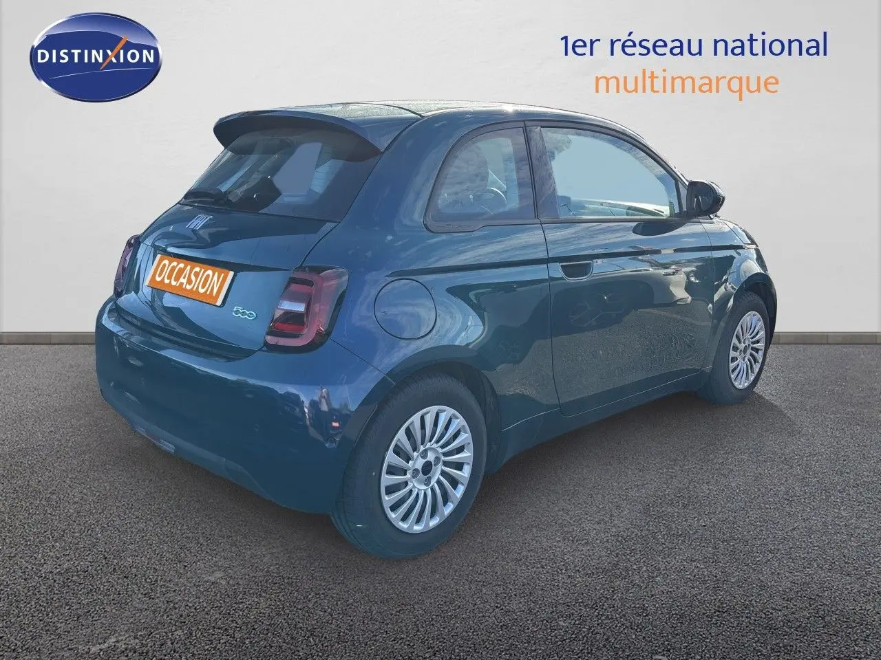 Vue 3/4 arrière droite d'une FIAT 500 électrique 2023 en vert océan métal avec jantes argentées et feux arrière LED.
