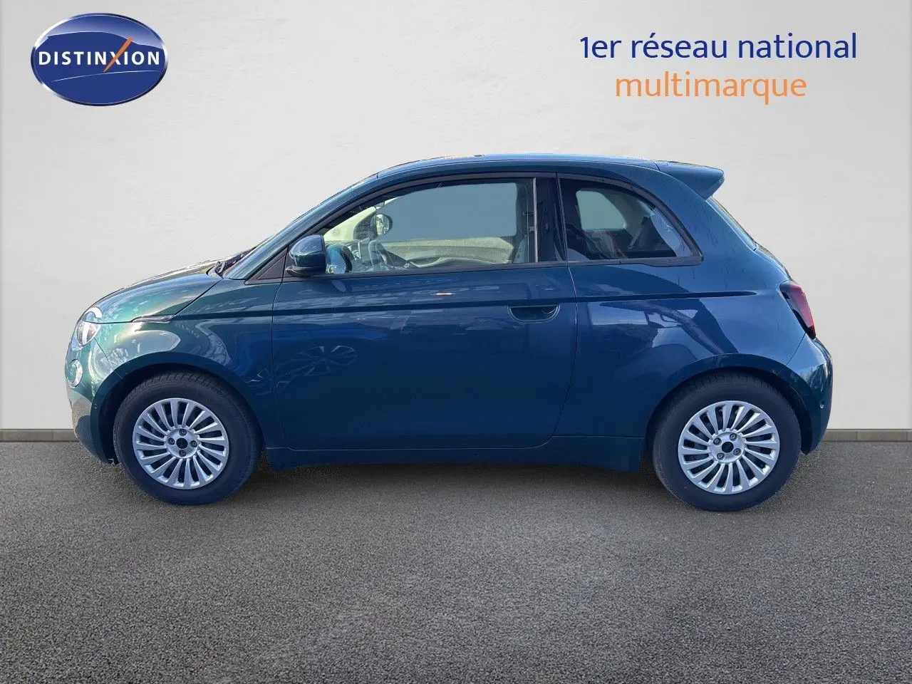 Profil droit de la Fiat 500 électrique 118ch 2023 en vert océan métal, avec jantes alliage et carrosserie lisse.