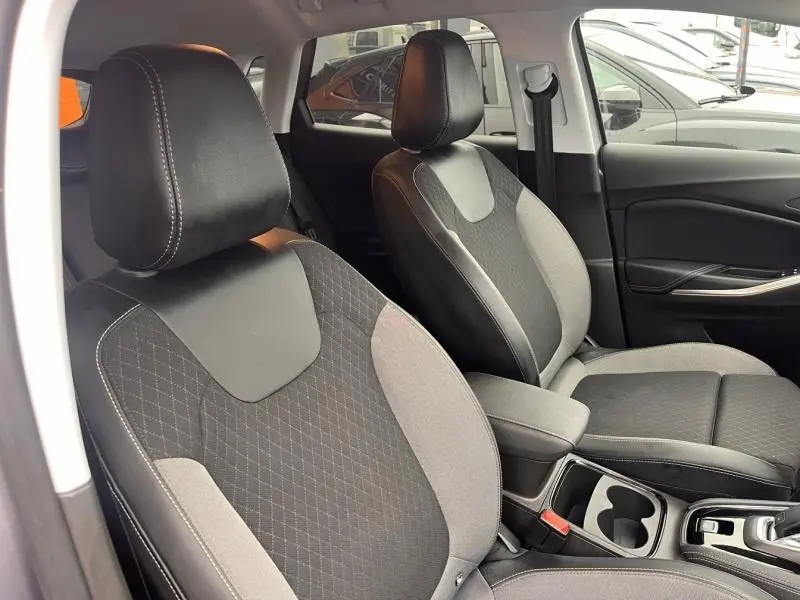 Vue intérieure côté avant droit du Opel Grandland 2023, sièges tissu noir et gris avec accoudoir central.