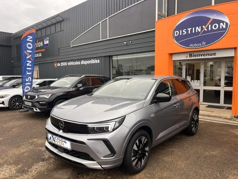 Opel Grandland gris Kontrast métallisé en 3/4 avant droit, avec jantes alliage bi-ton et calandre noire distinctive.