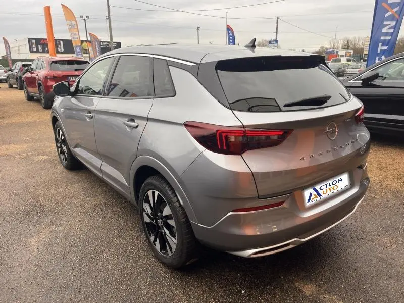 Vue 3/4 arrière droite d'un Opel Grandland gris Kontrast métallisé avec jantes bi-ton et vitres teintées.