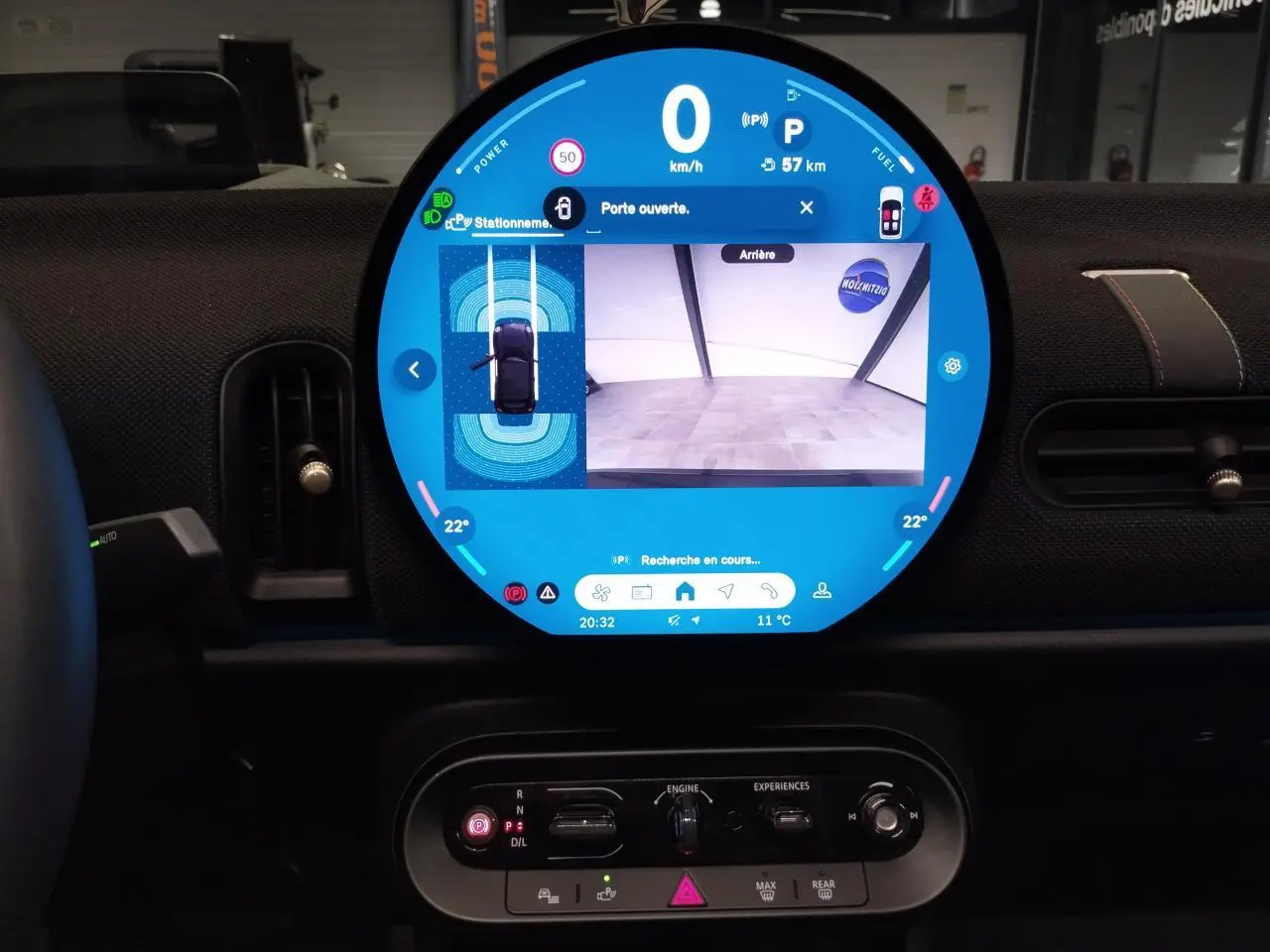 Vue intérieure centrée sur l'écran tactile rond affichant la caméra de recul, tableau de bord noir du MINI Cabriolet 2025.