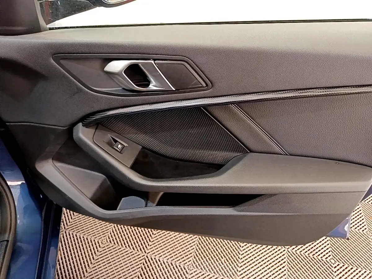 Vue rapprochée de la porte avant gauche bleu foncé de la BMW Série 1 118i Edition Sport avec poignée argentée.
