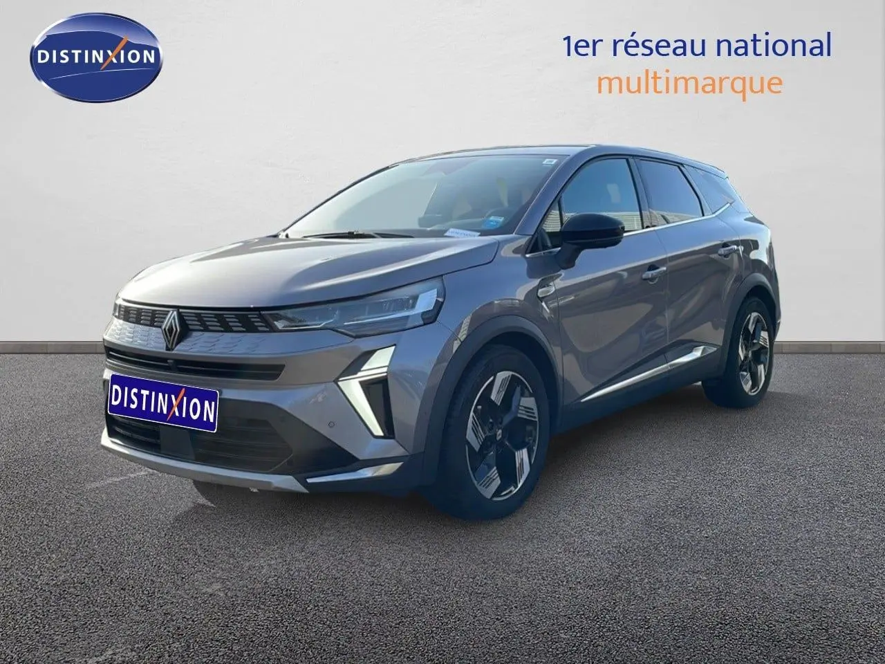 Renault Symbioz gris cassiopée métal en 3/4 avant droit, SUV hybride avec calandre distinctive et jantes bicolores.