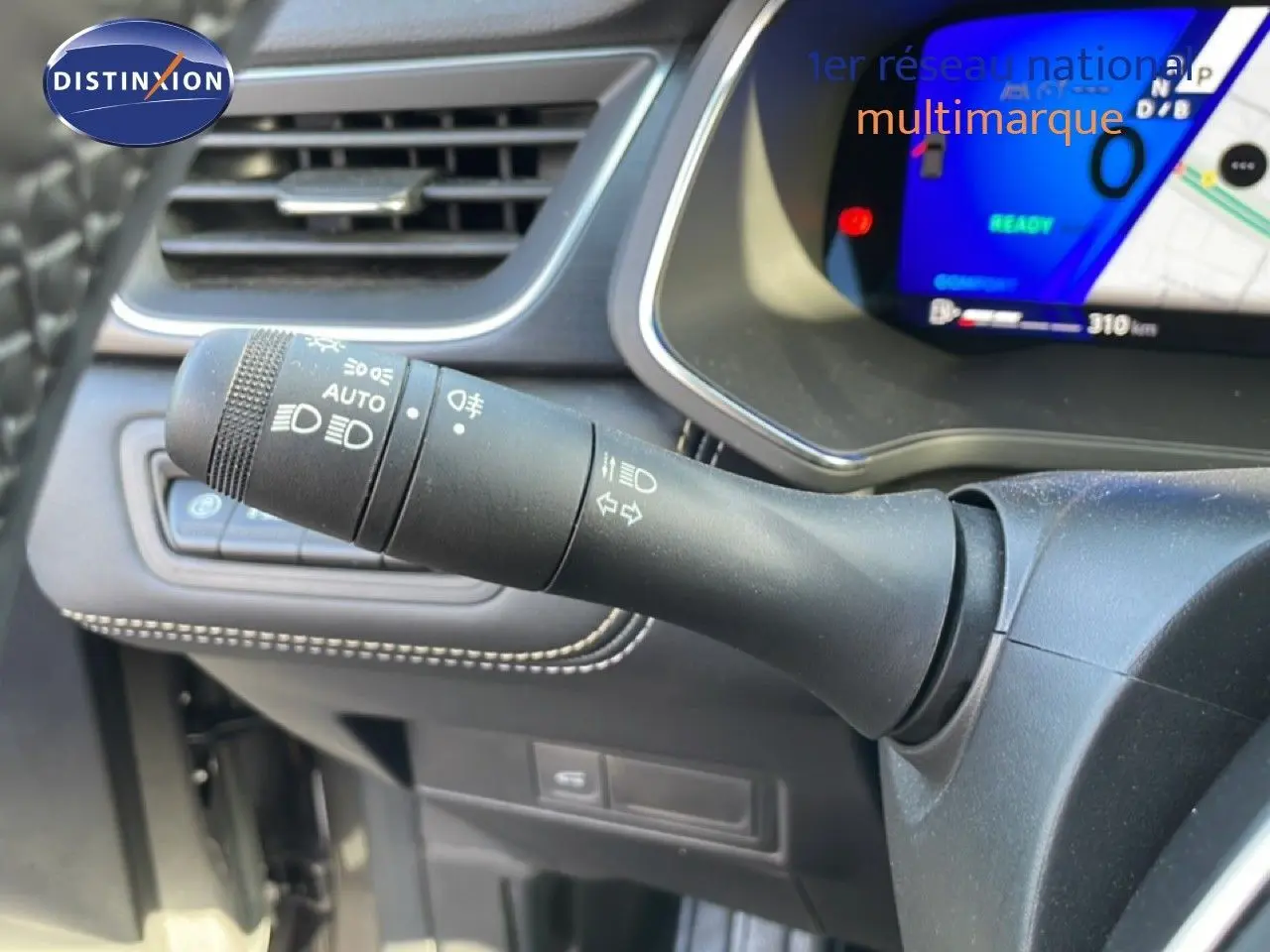 Gros plan sur la commande des phares et clignotants à gauche du volant dans l’habitacle du Renault Symbioz gris cassiopée métal.