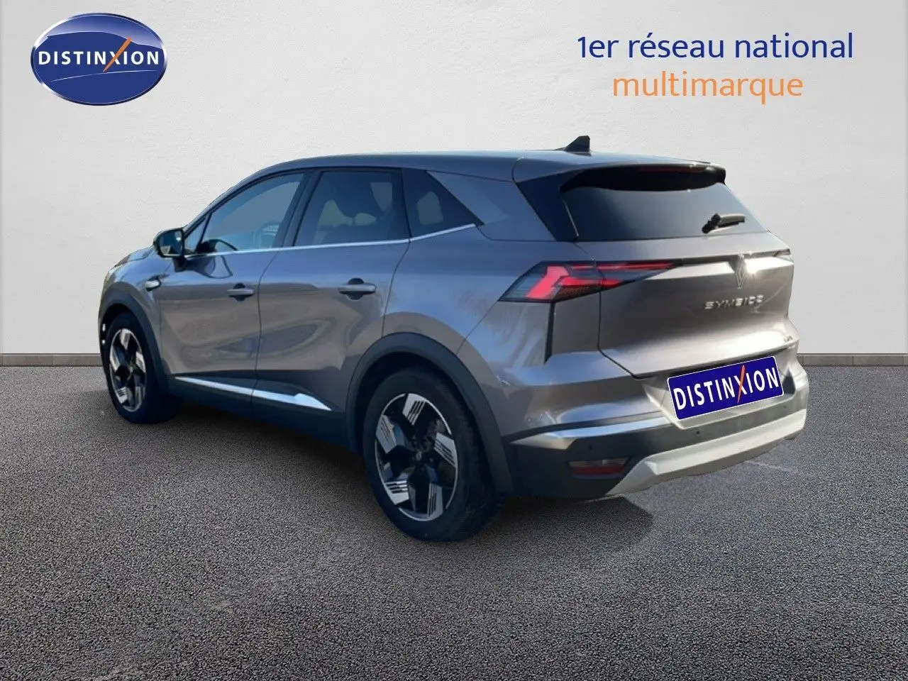 Vue 3/4 arrière droite d'un Renault Symbioz gris cassiopée métallisé avec jantes bicolores et feux LED distinctifs.