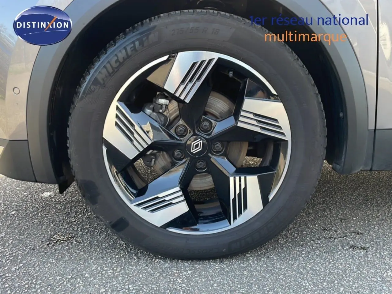 Gros plan sur la roue avant droite du Renault Symbioz gris cassiopée métal, mettant en valeur la jante noire et argentée au design géométrique.