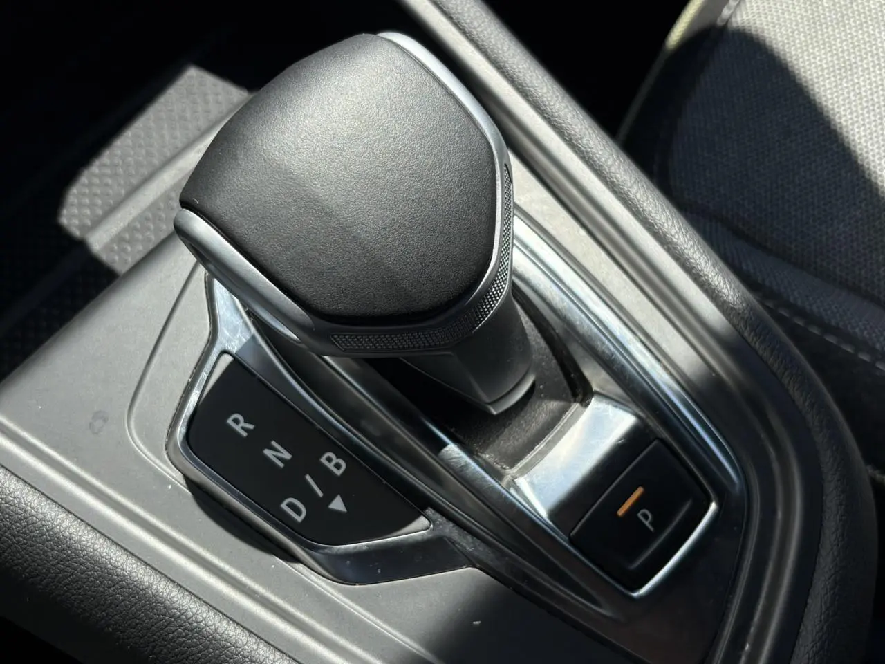 Le levier de vitesses automatique noir de la Renault SYMBIOZ E-Tech vu en gros plan intérieur.