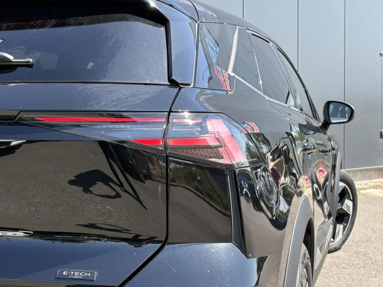Vue 3/4 arrière droite de la Renault SYMBIOZ E-Tech Full Hybrid 2025 en noir étoile avec feux arrière LED distinctifs.