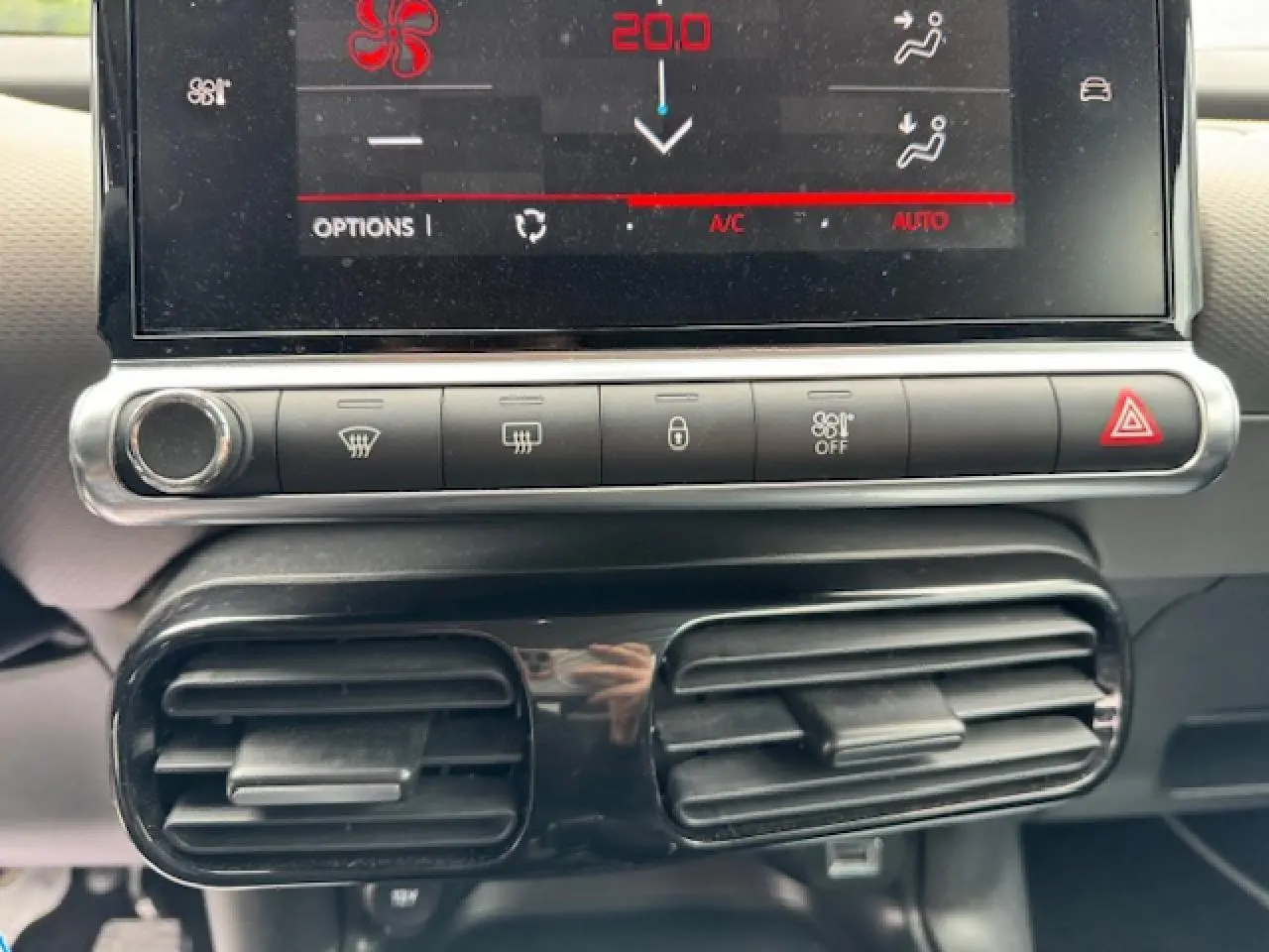 Gros plan sur la console centrale du Citroën C4 Cactus 2020, montrant l'écran tactile et les commandes de climatisation.