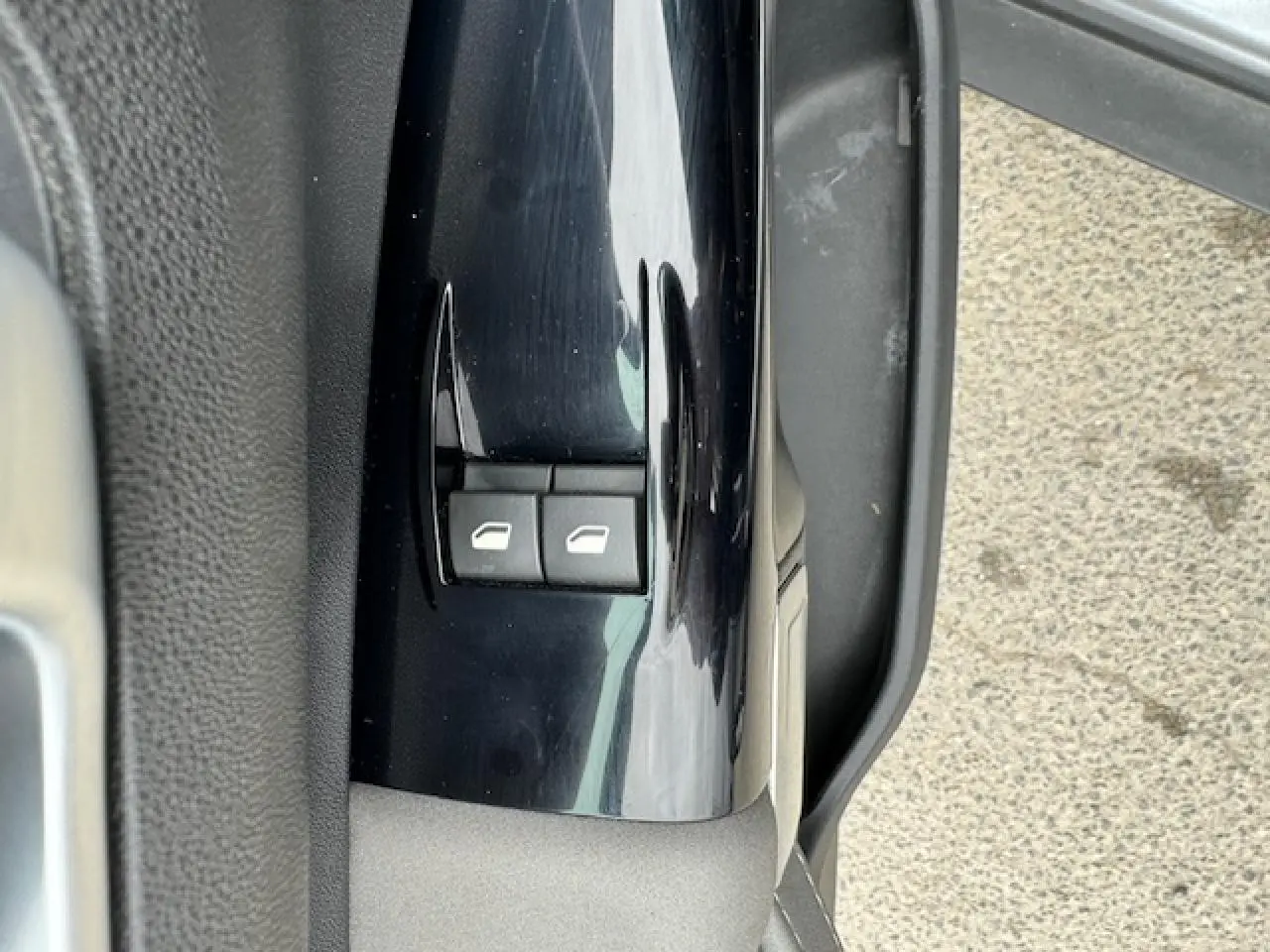 Gros plan sur les commandes de lève-vitres côté conducteur d'une Citroën C4 Cactus gris clair, portière ouverte.