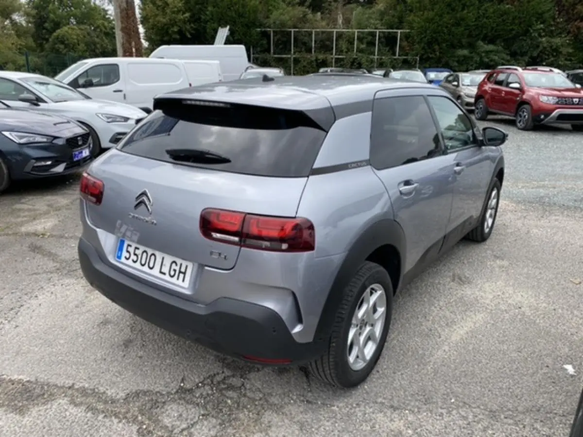 Vue 3/4 arrière droite d'une Citroën C4 Cactus gris clair avec vitres teintées et jantes acier 15 pouces.