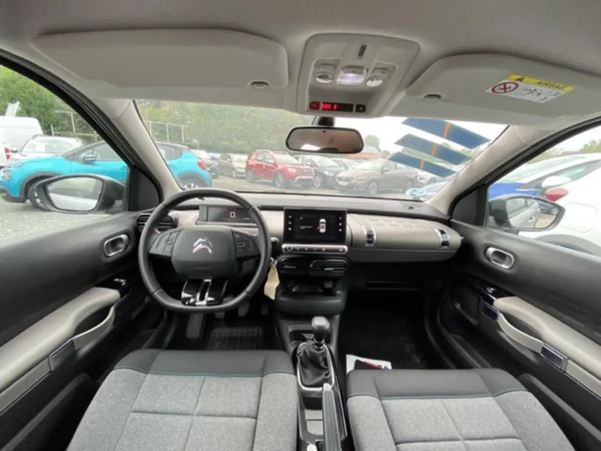 Intérieur de la Citroën C4 Cactus 2020 gris clair, vue frontale du tableau de bord avec volant et écran tactile.