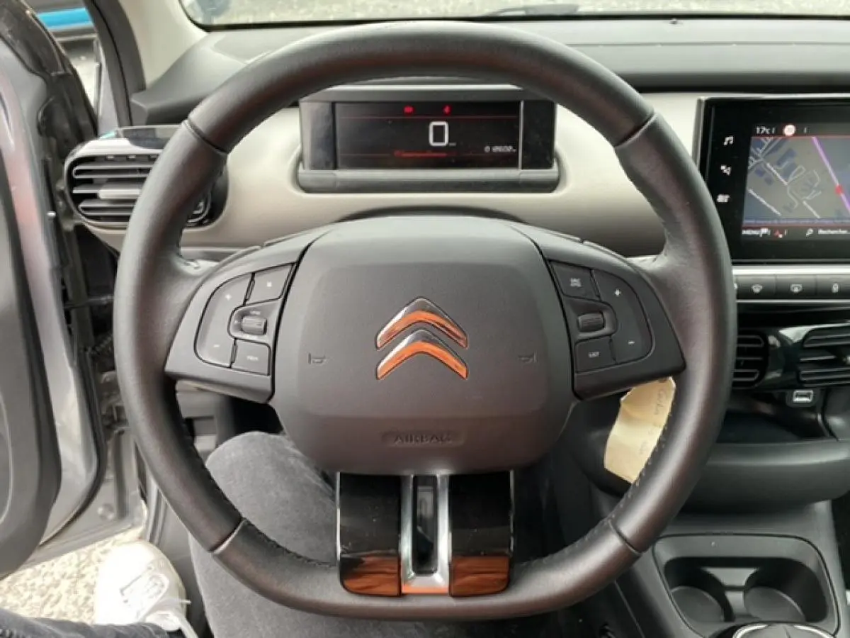 Vue intérieure centrée sur le volant noir de la Citroën C4 Cactus 2020, avec tableau de bord numérique et écran tactile visible.