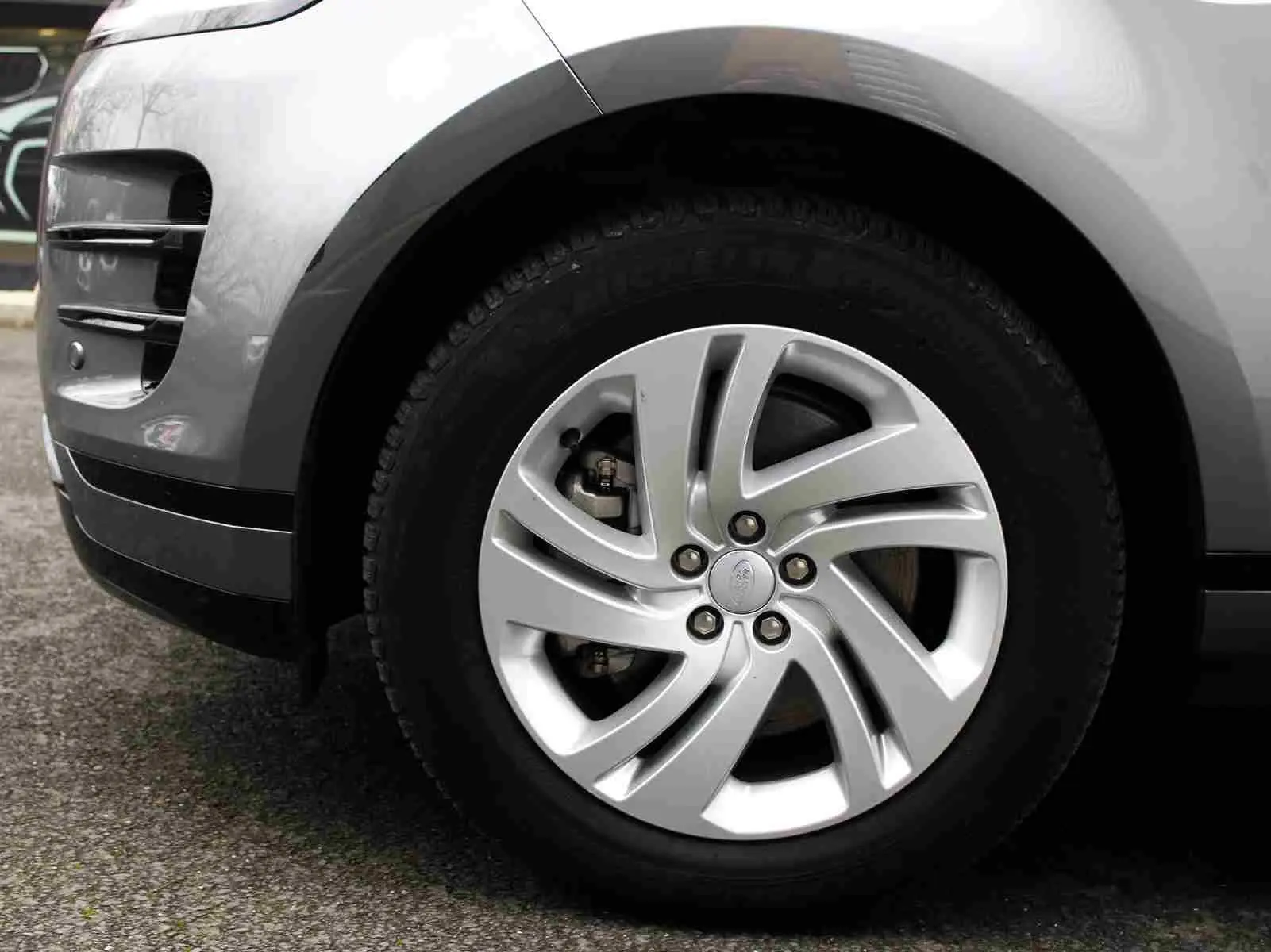 Vue arrière d'un Range Rover Evoque gris métal 2023 avec coffre ouvert et intérieur de coffre vide.