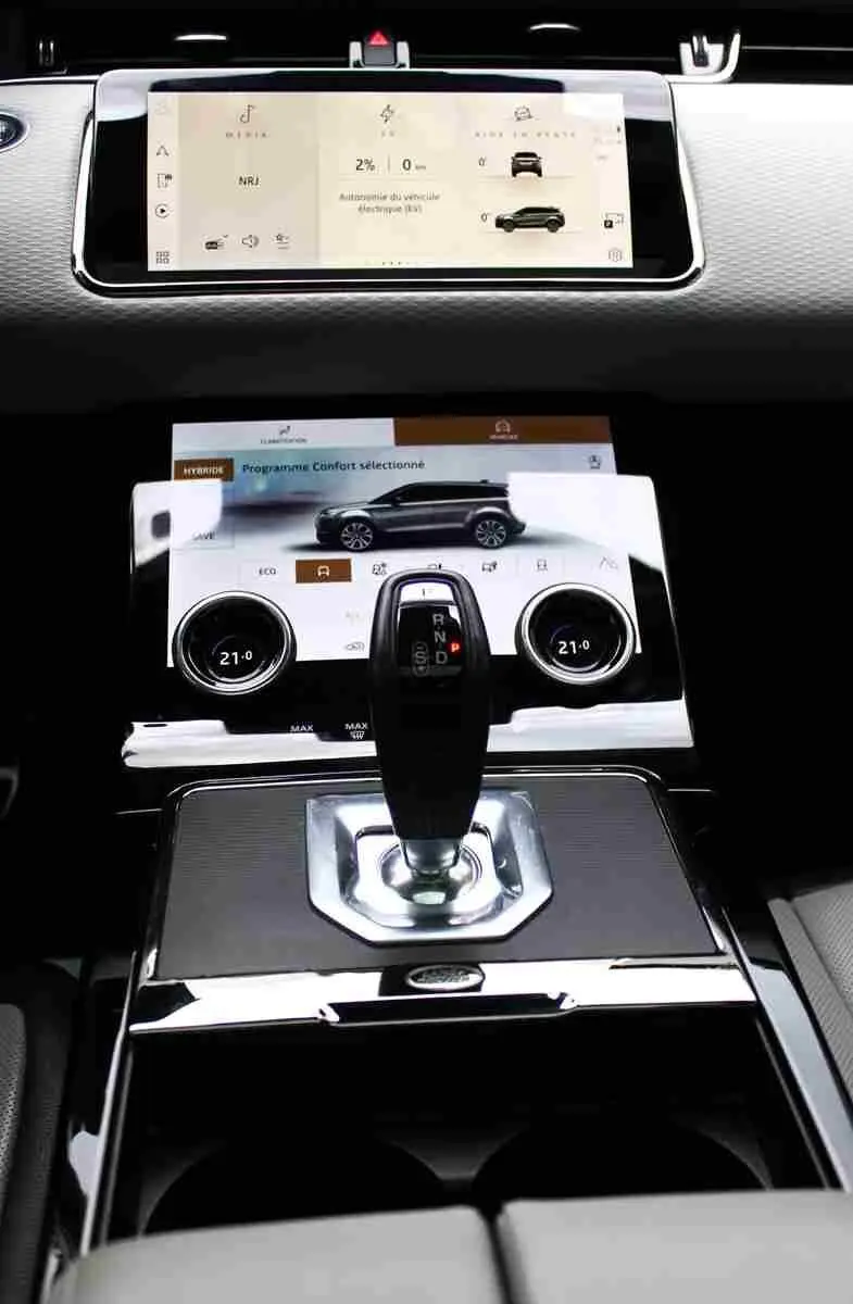 Vue intérieure centrée sur le volant gris clair et tableau de bord digital du Range Rover Evoque hybride rechargeable 2023.