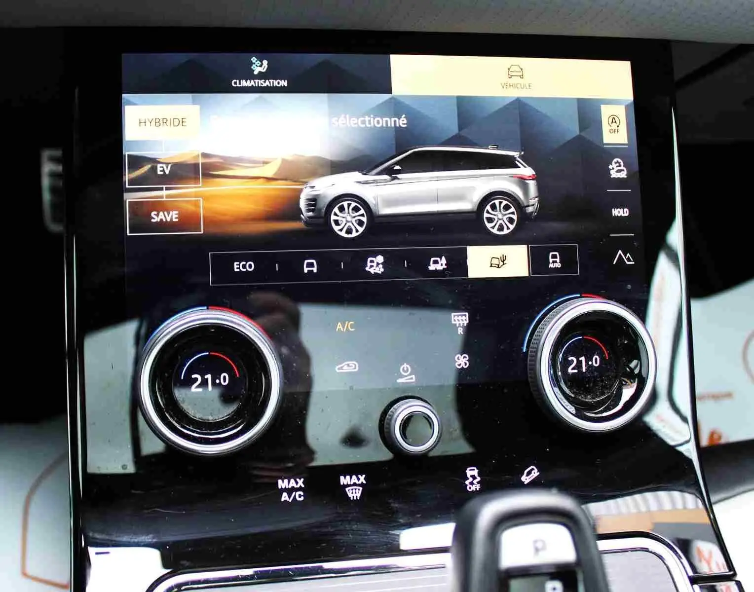 Gros plan sur la commande des vitres et rétroviseurs côté conducteur du Range Rover Evoque gris métal 2023 hybride rechargeable.