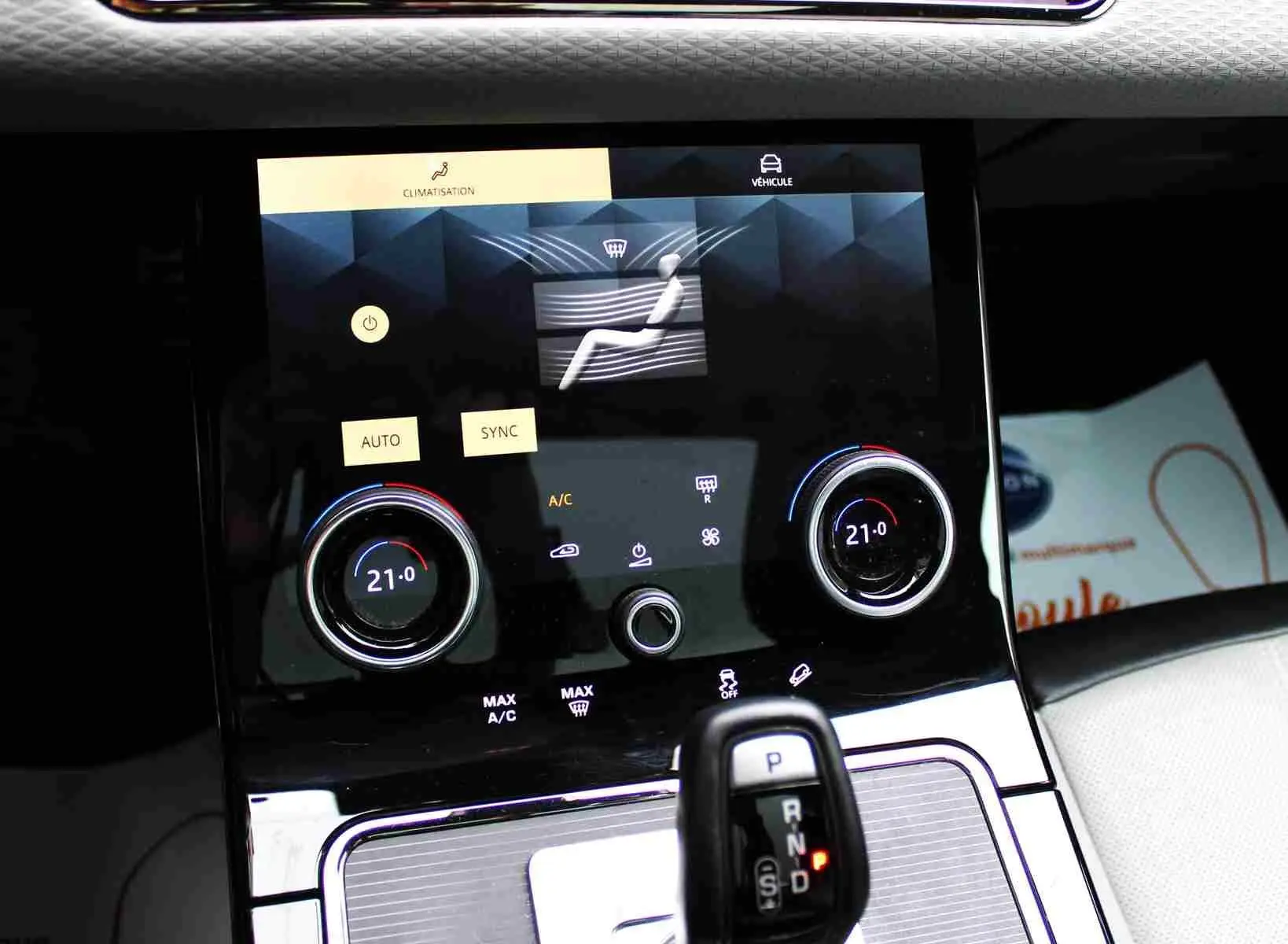 Gros plan sur le volant gris clair du Range Rover Evoque 2023 avec commandes tactiles intégrées.