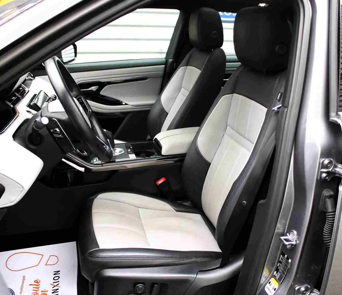 Vue 3/4 arrière droite d'un Range Rover Evoque gris métal 2023 hybride rechargeable avec plaque "OCCASION".