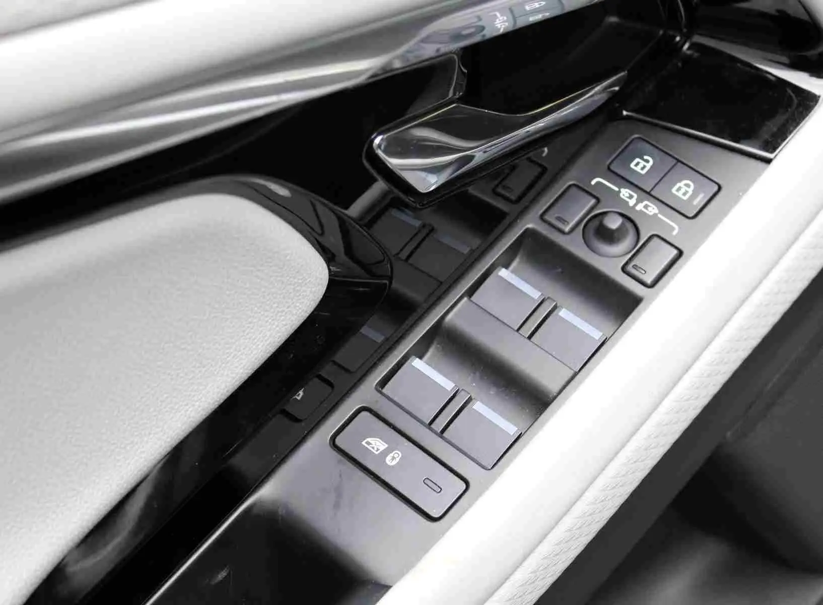 Vue rapprochée de la console centrale du Range Rover Evoque 2023 gris métal, affichant le mode hybride et la climatisation.