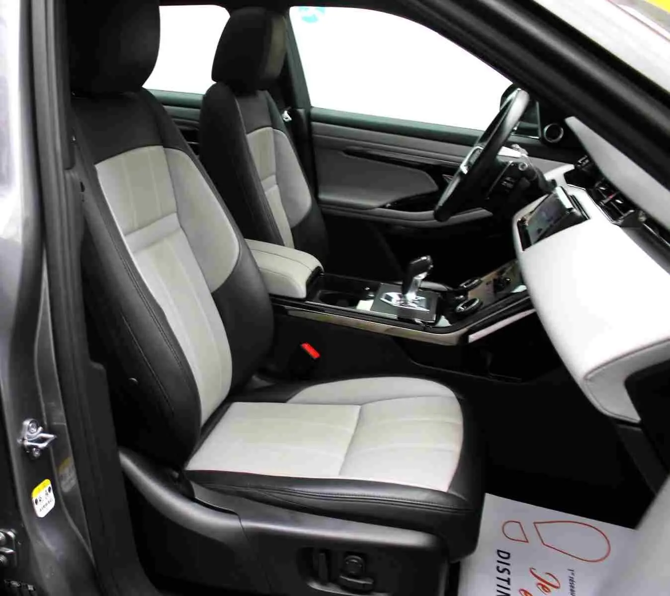 Vue arrière d'un Range Rover Evoque gris métal 2023 avec logo Land Rover et plaque "OCCASION" visible.