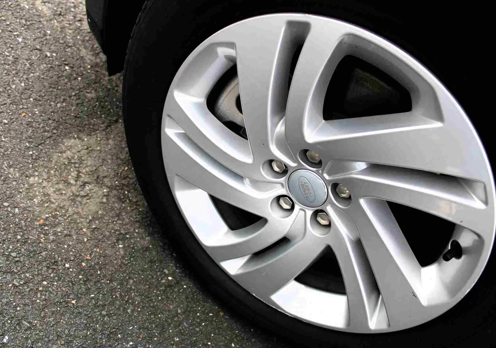 Gros plan sur la jante argentée du Range Rover Evoque 2023, mettant en valeur le logo Land Rover au centre.