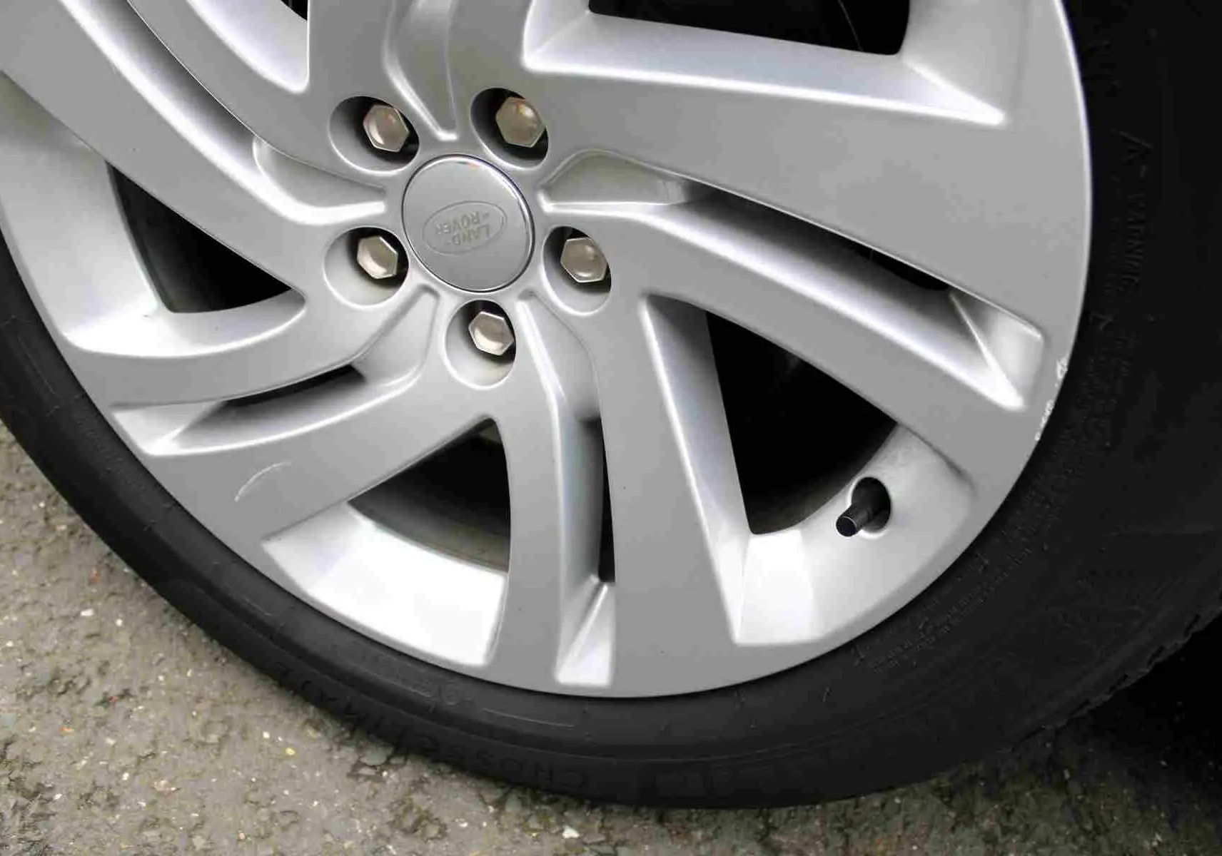 Gros plan sur la partie arrière grise métallisée du Range Rover Evoque 2023, montrant une rayure visible sur la carrosserie.