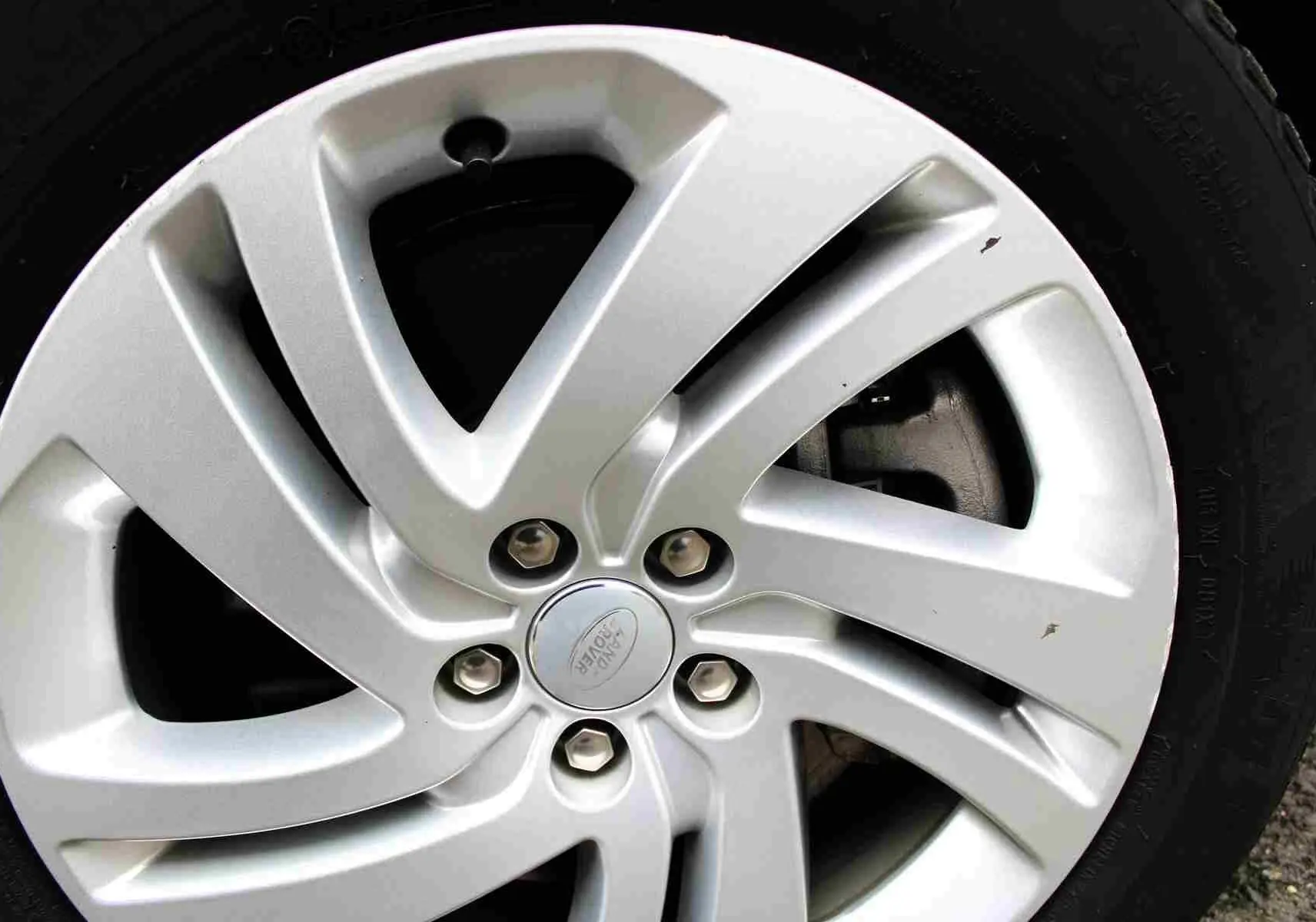 Gros plan sur la jante argentée du Range Rover Evoque 2023 gris métal, version hybride rechargeable.