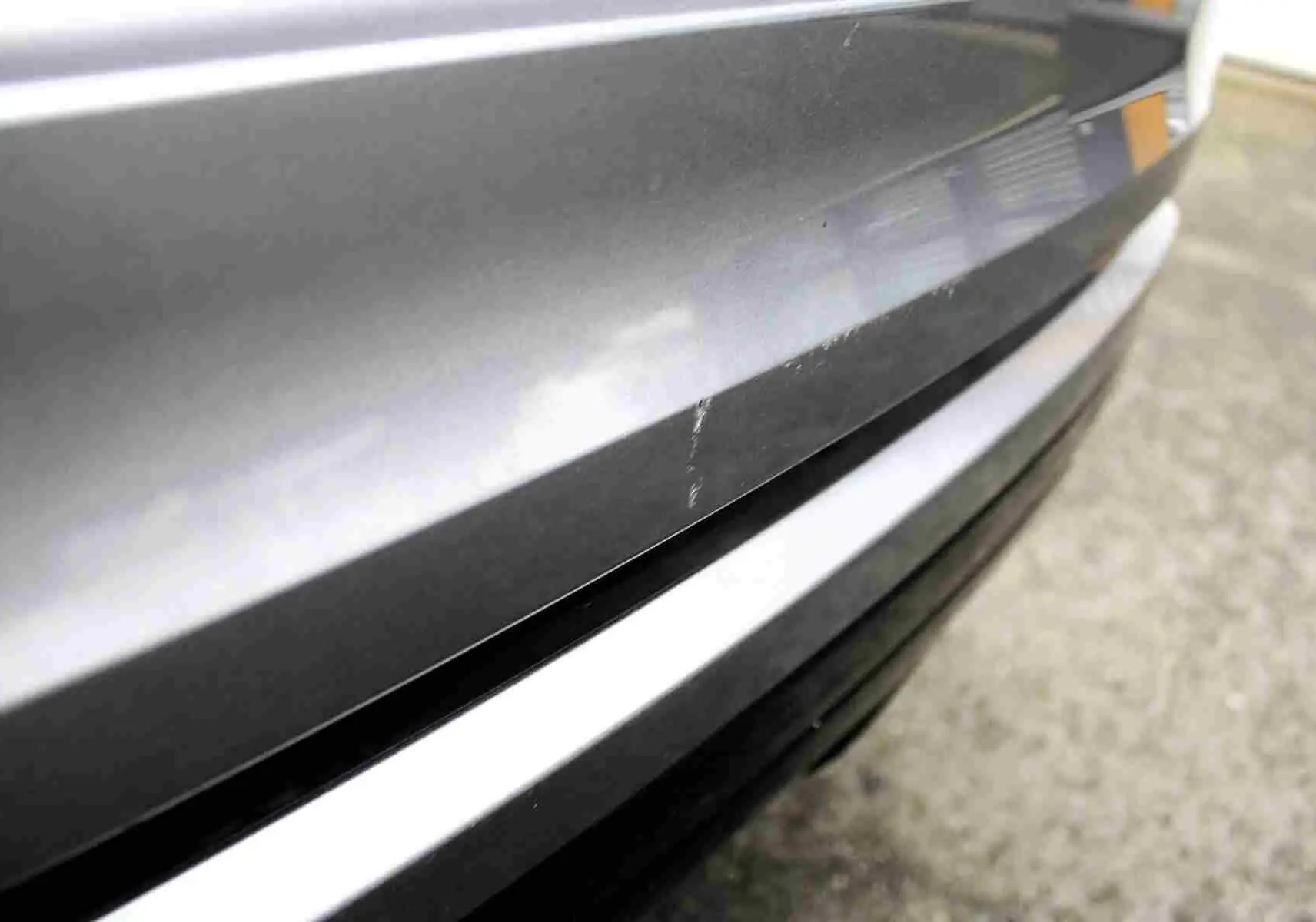 Gros plan sur la console centrale du Range Rover Evoque 2023 gris métal, affichant la climatisation digitale et le levier de vitesse.