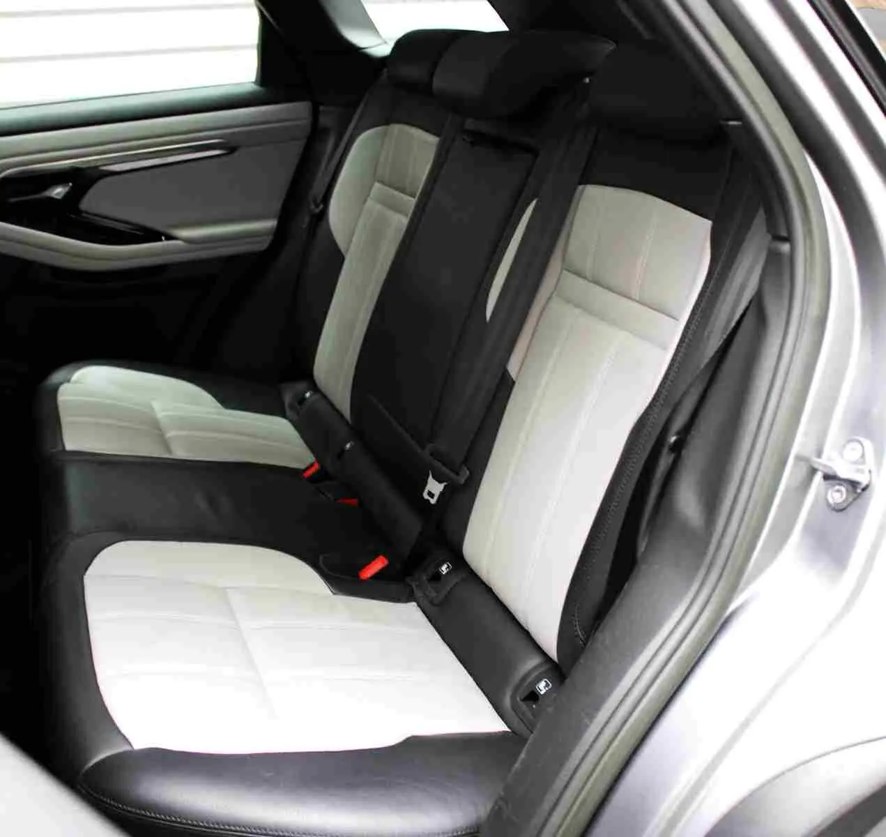 Range Rover Evoque gris métal en 3/4 avant droit, avec calandre noire et plaque "OCCASION" orange visible.