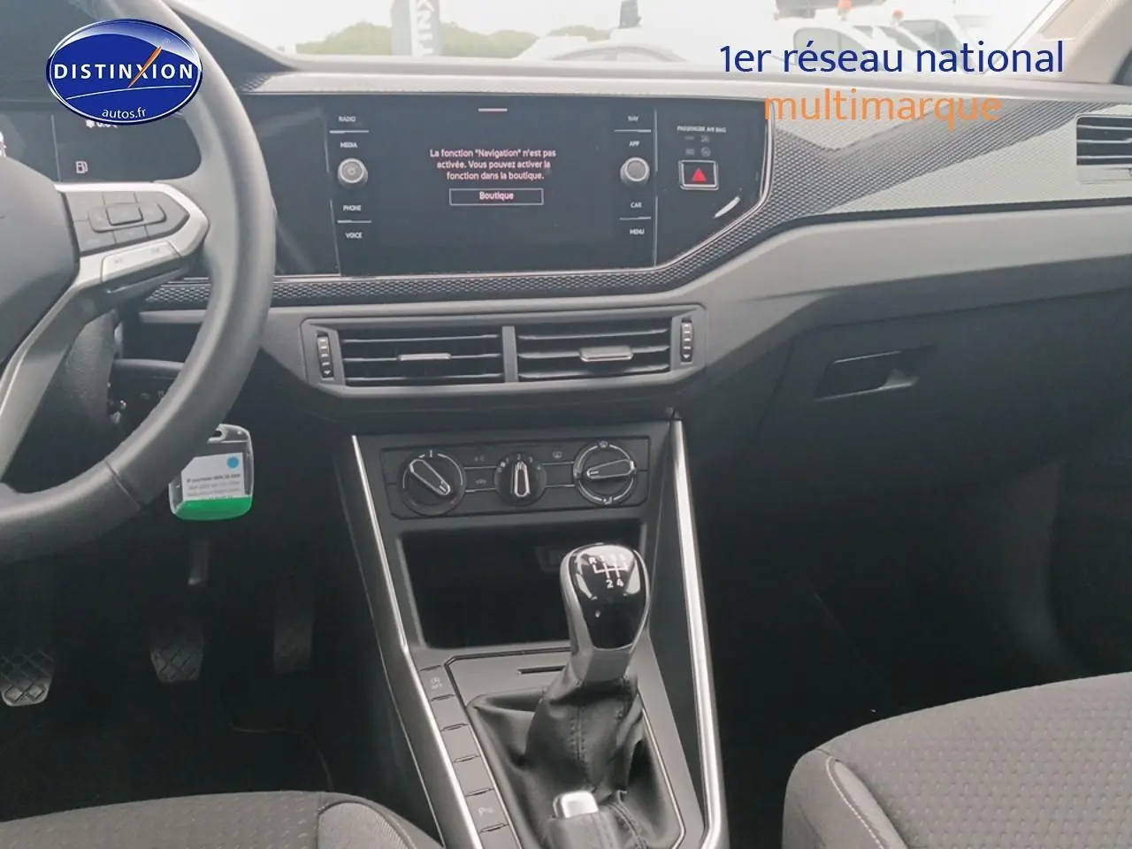 Vue intérieure centrée sur la console centrale et levier de vitesses manuelle d'une Volkswagen Polo blanche 2025.