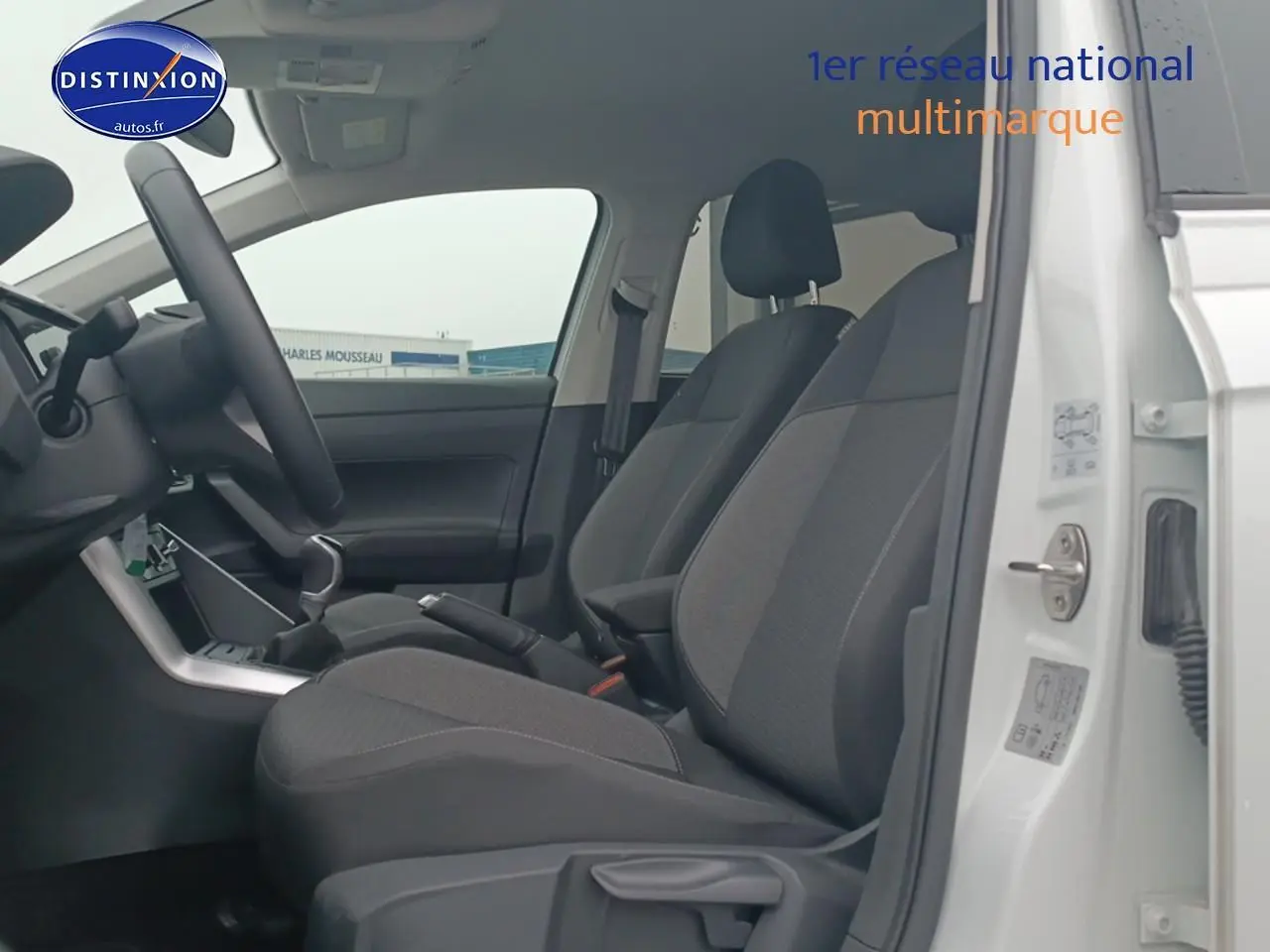 Vue intérieure côté gauche sur les sièges avant noirs et la porte ouverte d'une Volkswagen Polo blanche 2025.