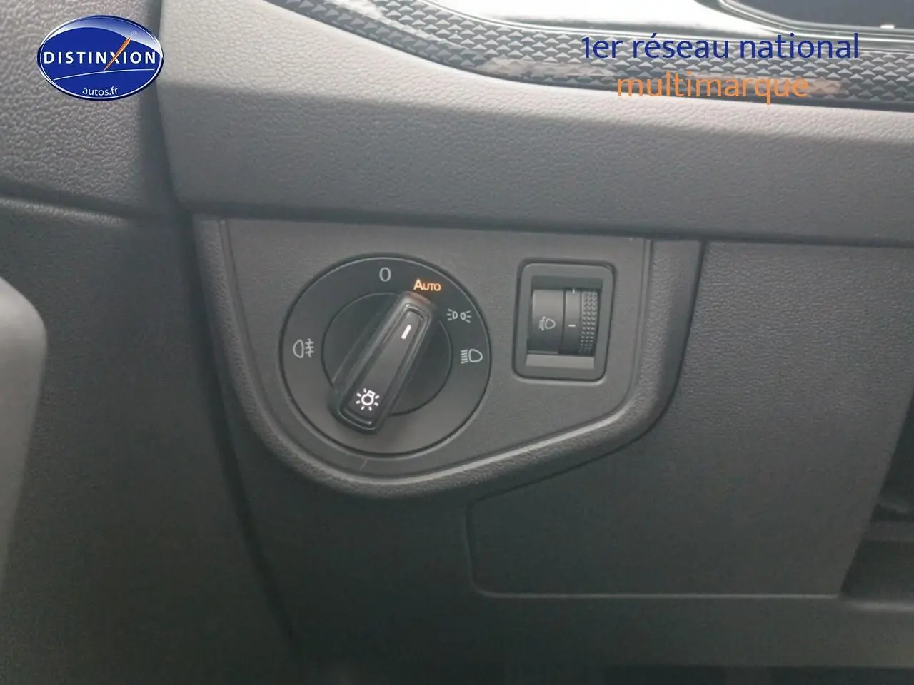 Gros plan sur le bouton de commande des phares du tableau de bord noir de la Volkswagen Polo blanche 2025.