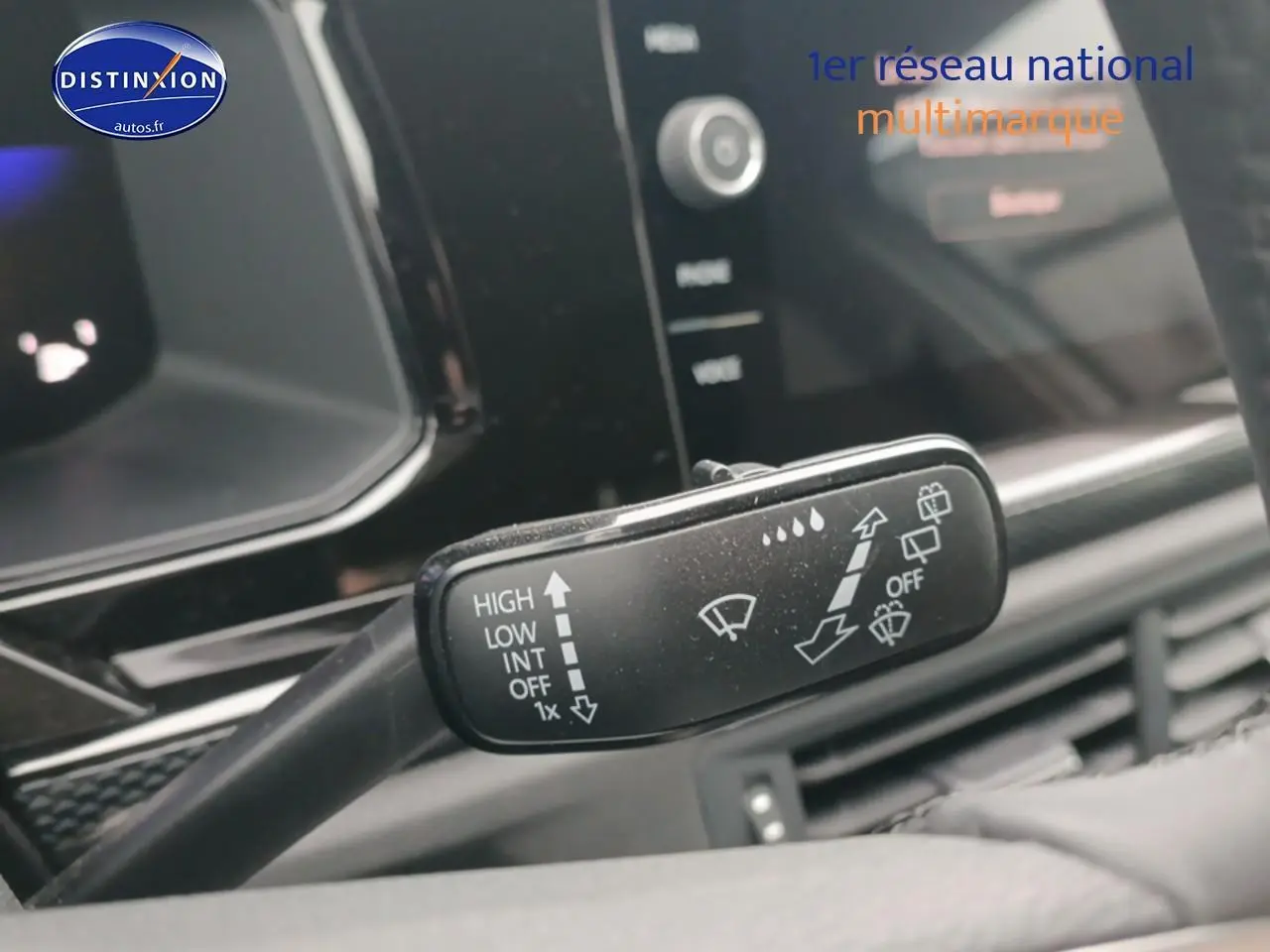 Gros plan sur la commande des essuie-glaces dans l’habitacle d’une Volkswagen Polo blanche, côté gauche du volant.