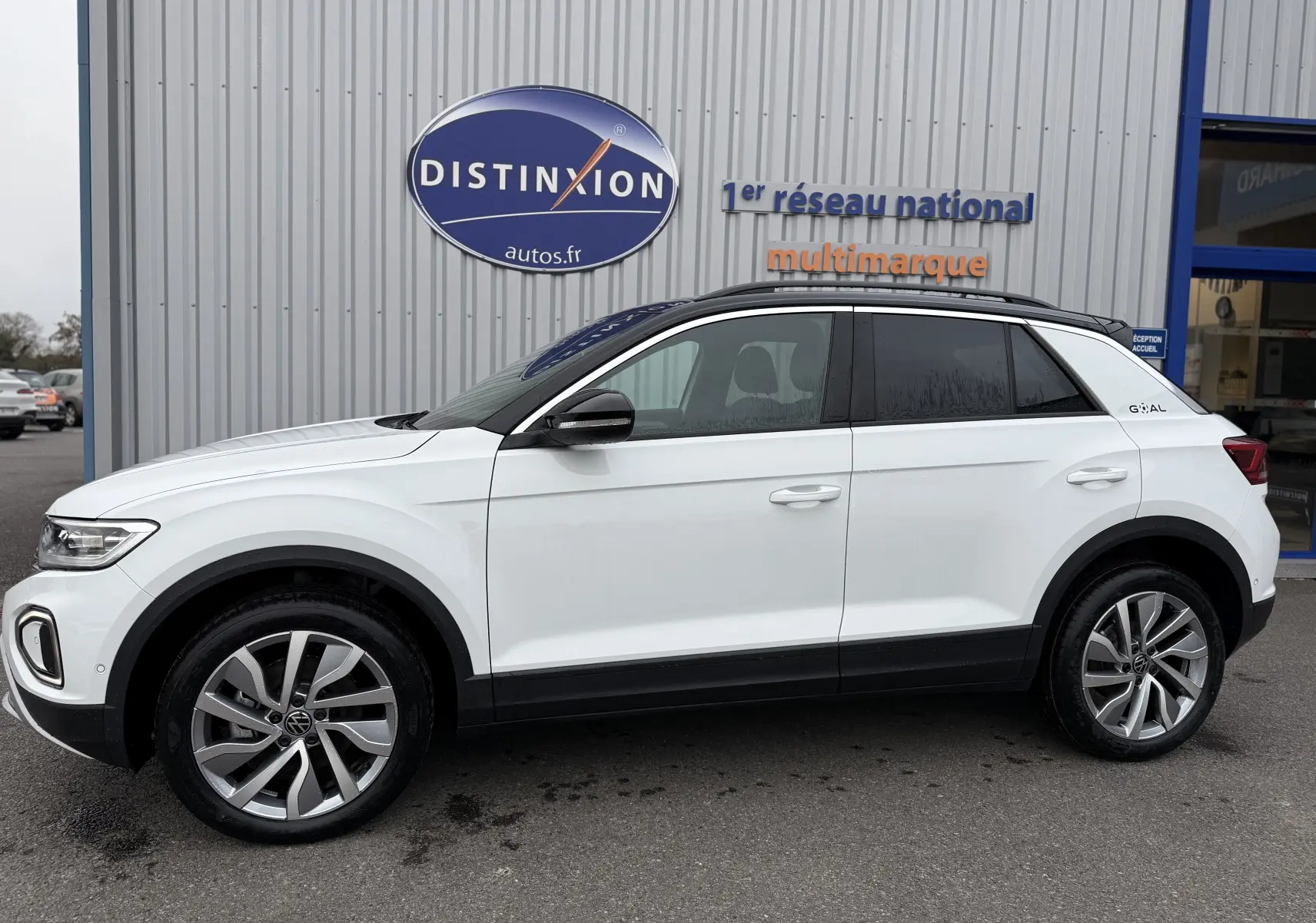 Vue de profil côté gauche d’un Volkswagen T-Roc blanc Pure avec toit noir, roues alliage et détails noirs au bas de caisse.