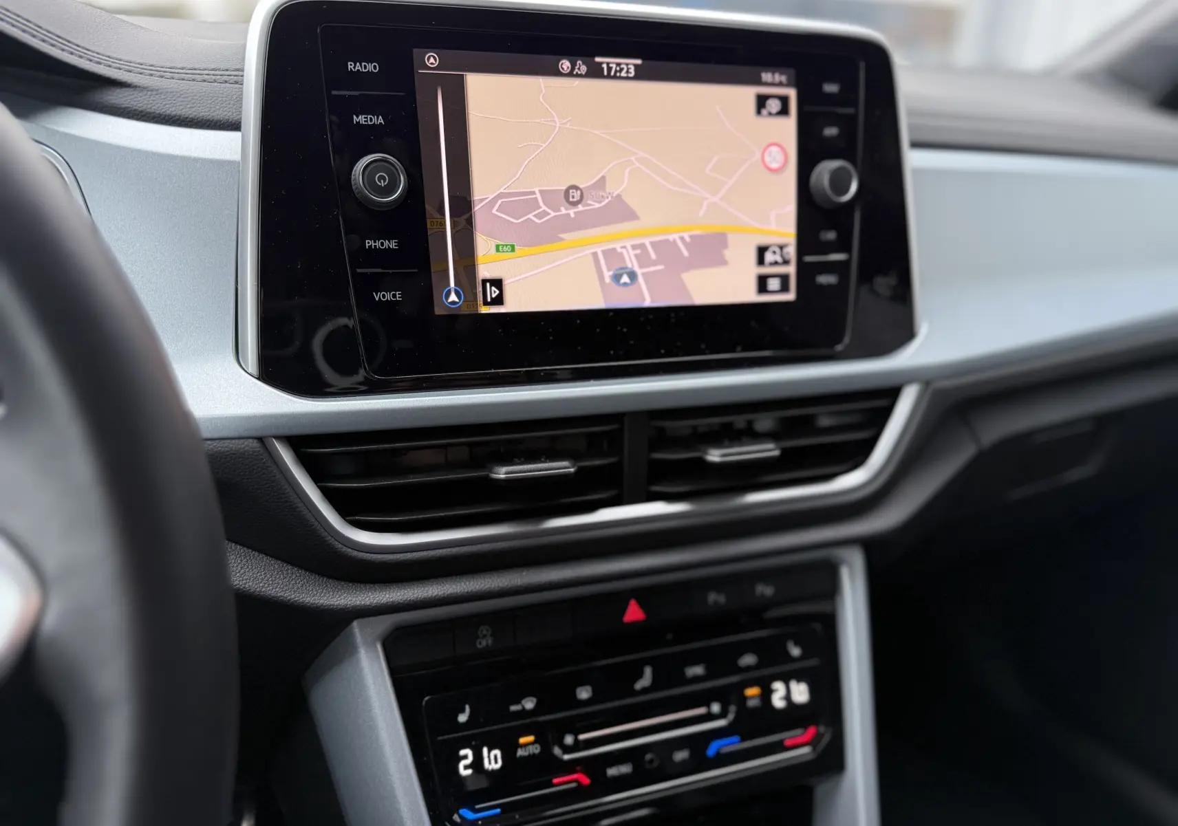 Vue rapprochée de l’écran tactile central et de la console de climatisation du Volkswagen T-Roc 2025, intérieur gris clair.