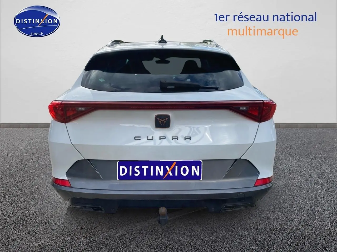 Vue arrière d'un CUPRA Formentor blanc 2023 avec feux LED reliés et attelage visible.