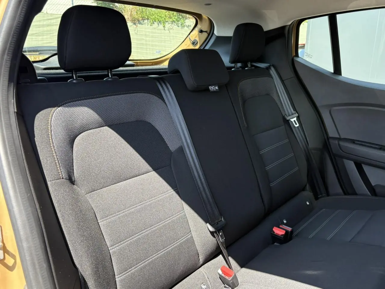 Vue intérieure côté gauche sur la banquette arrière noire du Dacia Sandero Stepway 2025 Beige Safari.