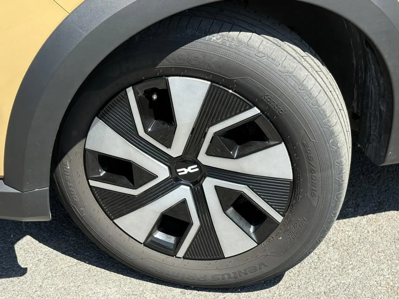 Gros plan sur la roue avant gauche du Dacia Sandero Stepway beige Safari avec jante au design noir et gris.