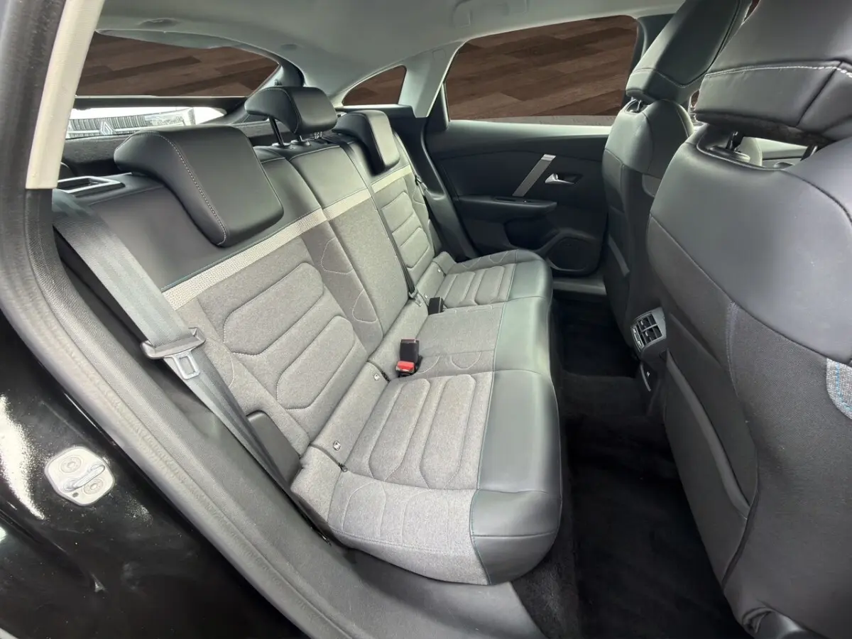 Vue intérieure côté arrière gauche de la banquette arrière bicolore gris et noir de la Citroën C4 noire 2023.