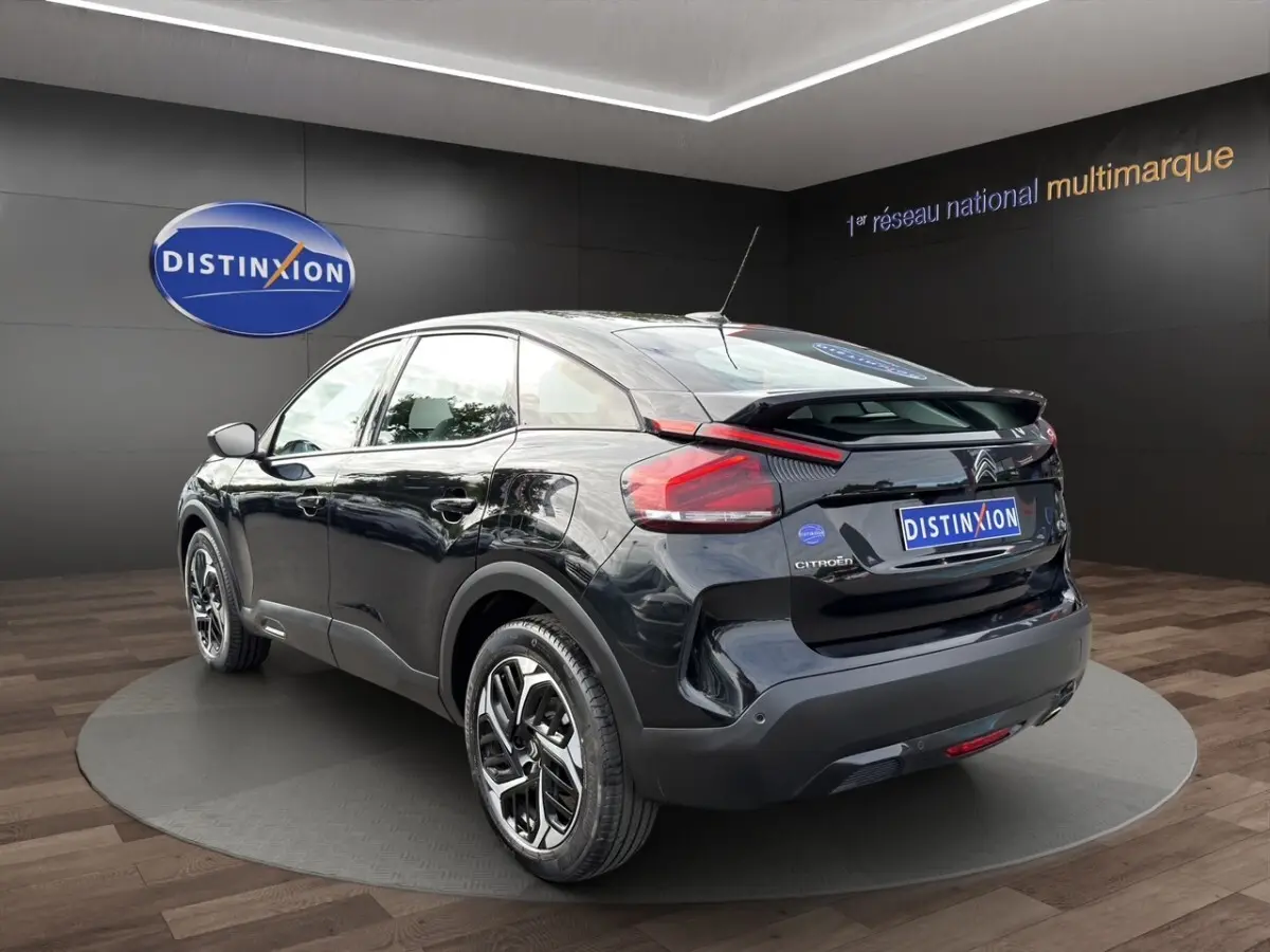 Vue 3/4 arrière droite d'une Citroën C4 noire 2023 avec jantes stylisées et feux arrière LED distinctifs.