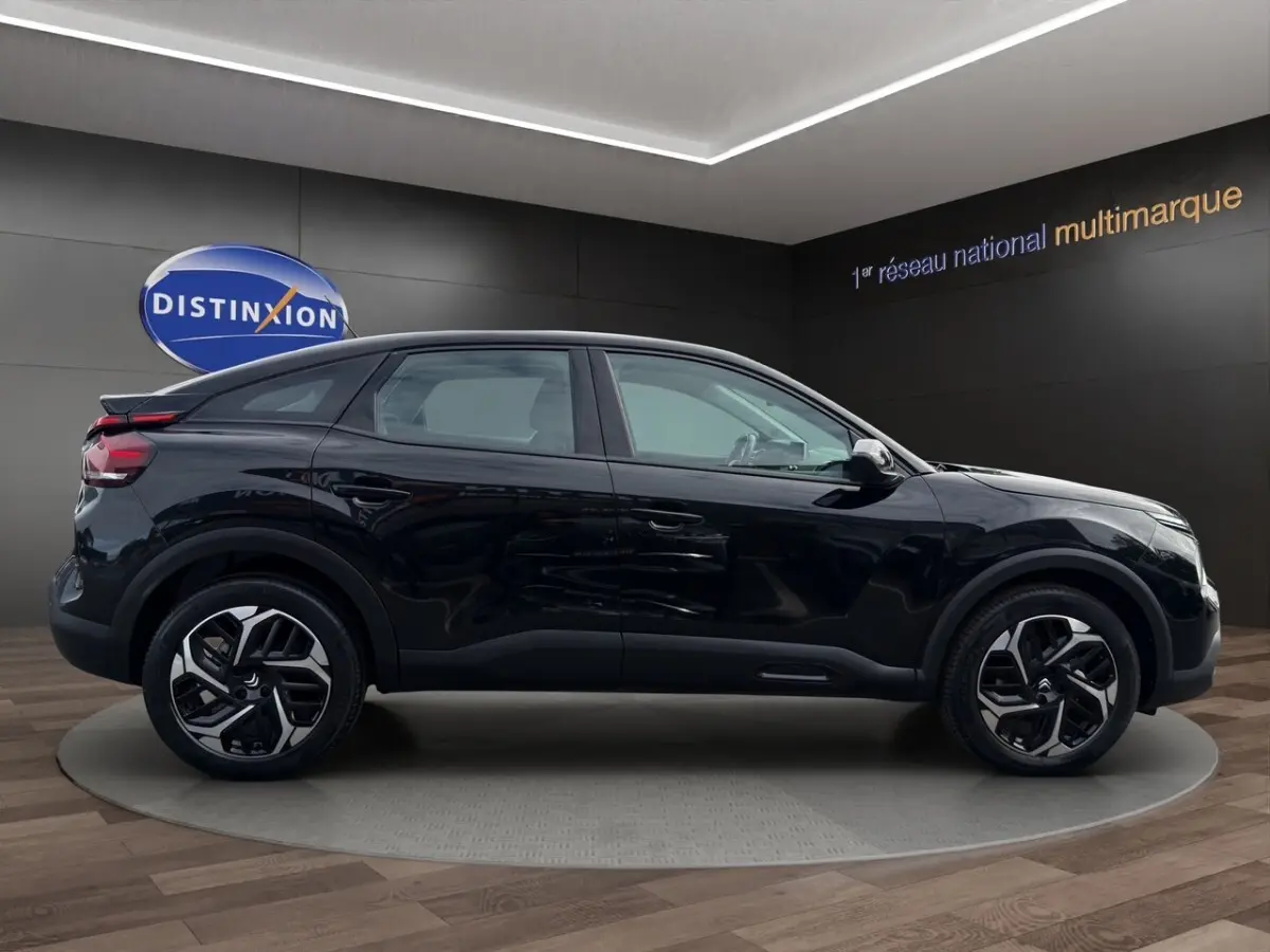 Profil droit d'une Citroën C4 noire 2023 avec jantes alliage et toit légèrement incliné en arrière.