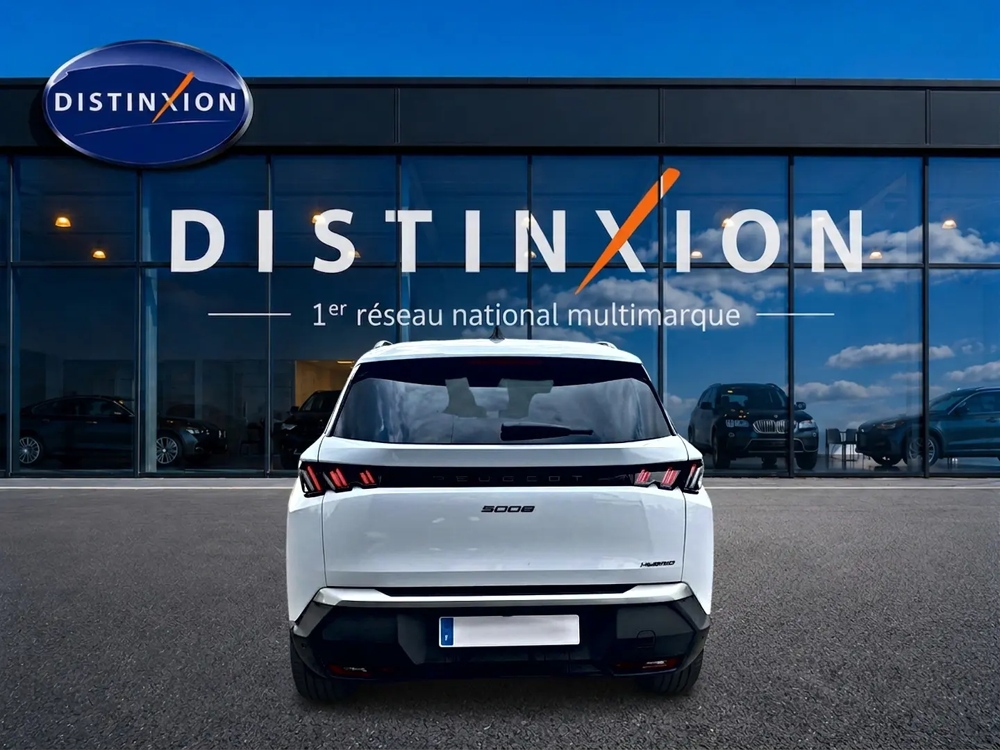 Vue arrière d'un Peugeot 5008 blanc Hybrid 145 allure e-dcs6 2025, avec feux arrière LED et lunette arrière surteintée.