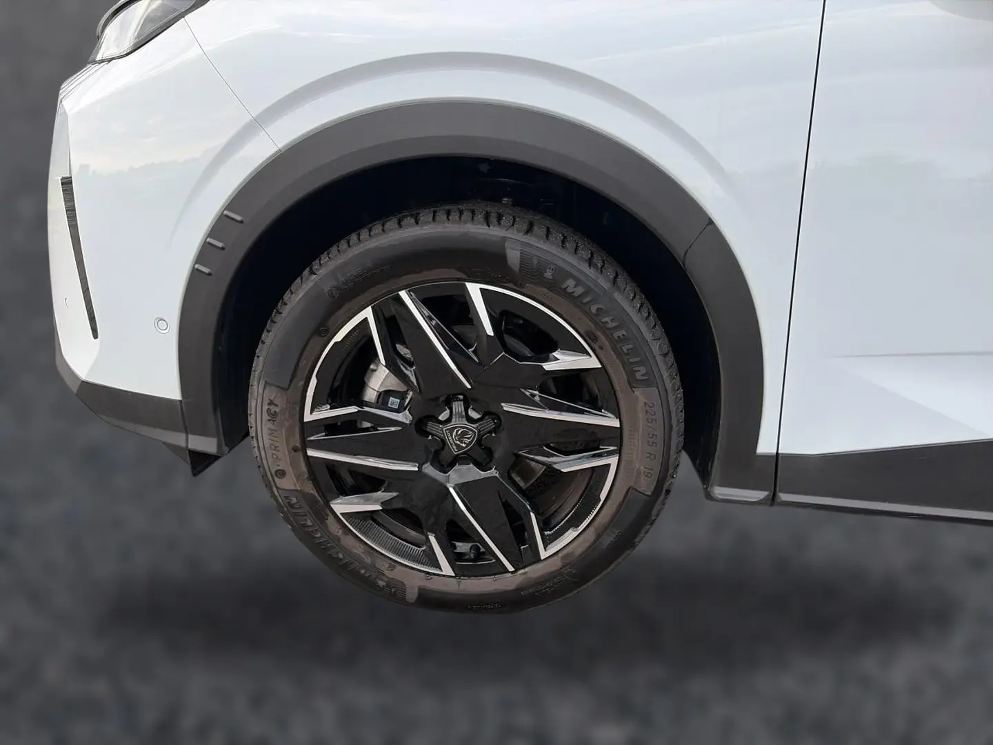 Gros plan sur la roue avant droite noire et argentée du Peugeot 5008 blanc, soulignant le design des jantes alu.
