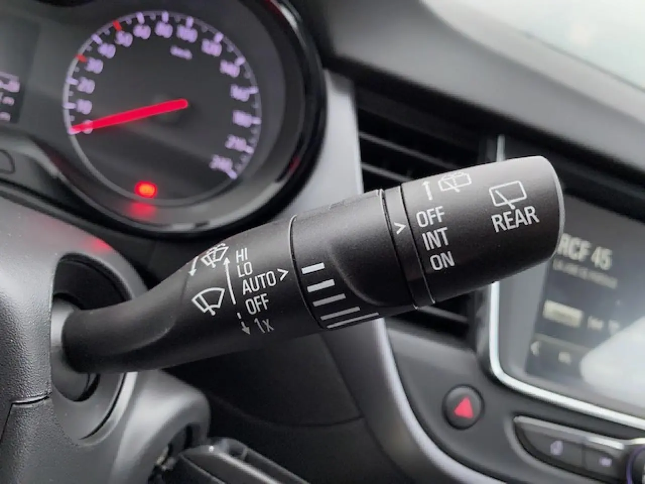 Gros plan sur la commande des essuie-glaces dans l'habitacle d'un Opel Crossland gris métallisé 2022.