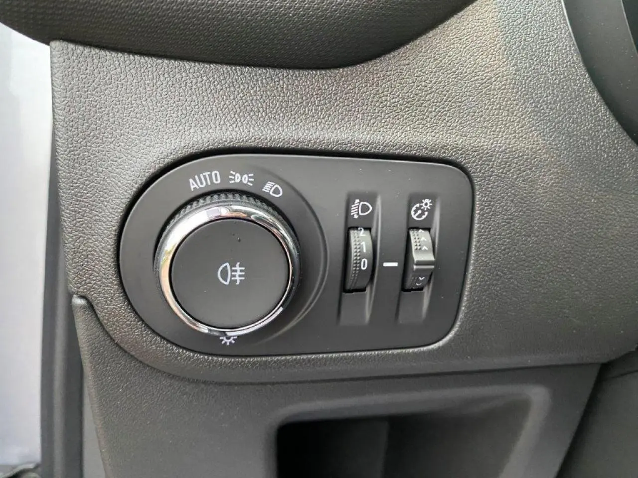 Commande des phares et réglages d'éclairage sur le tableau de bord intérieur de l'Opel Crossland gris métallisé.