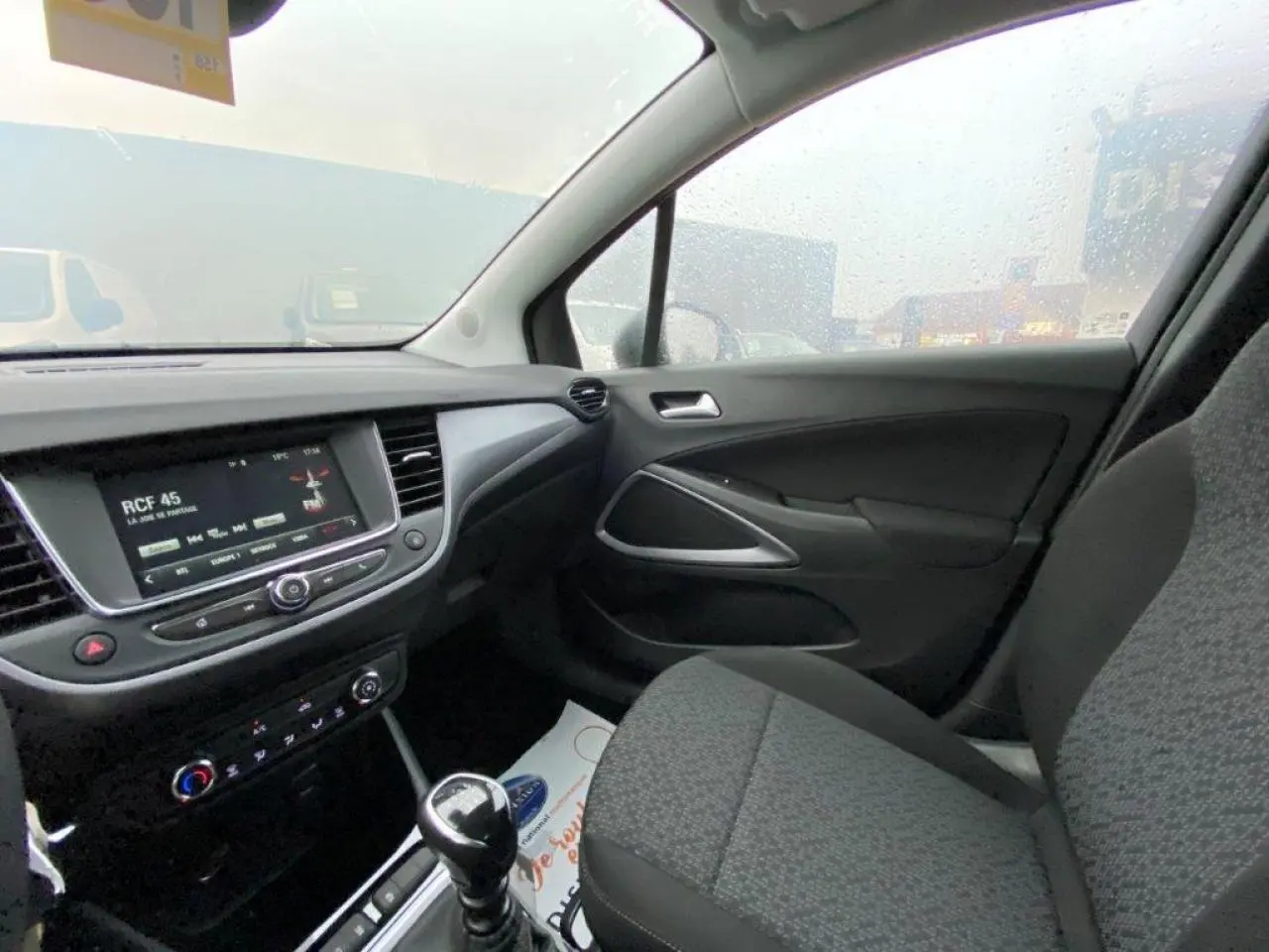 Intérieur de l'Opel Crossland gris métallisé, vue côté passager montrant la console centrale et l'écran tactile.