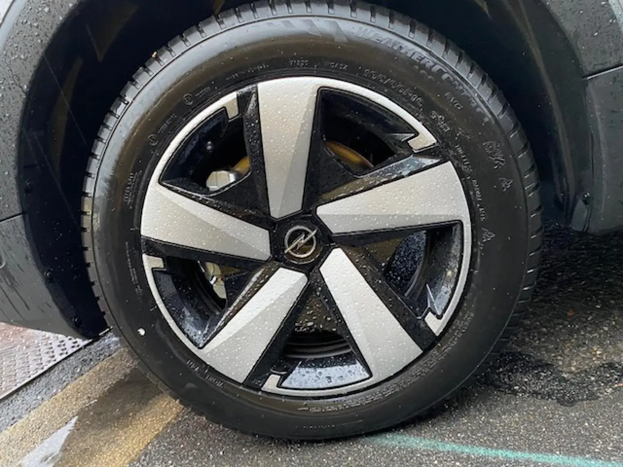 Gros plan sur la roue avant droite d'un Opel Crossland gris métallisé 2022 avec jante bicolore au design moderne.