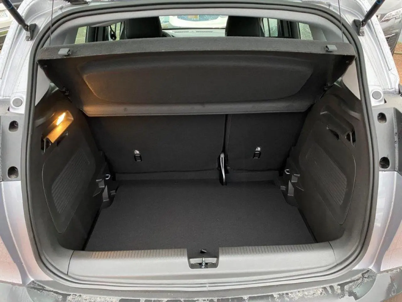 Coffre ouvert de l'Opel Crossland gris métallisé 2022, vue arrière montrant l'espace de chargement vide et l'éclairage intérieur.