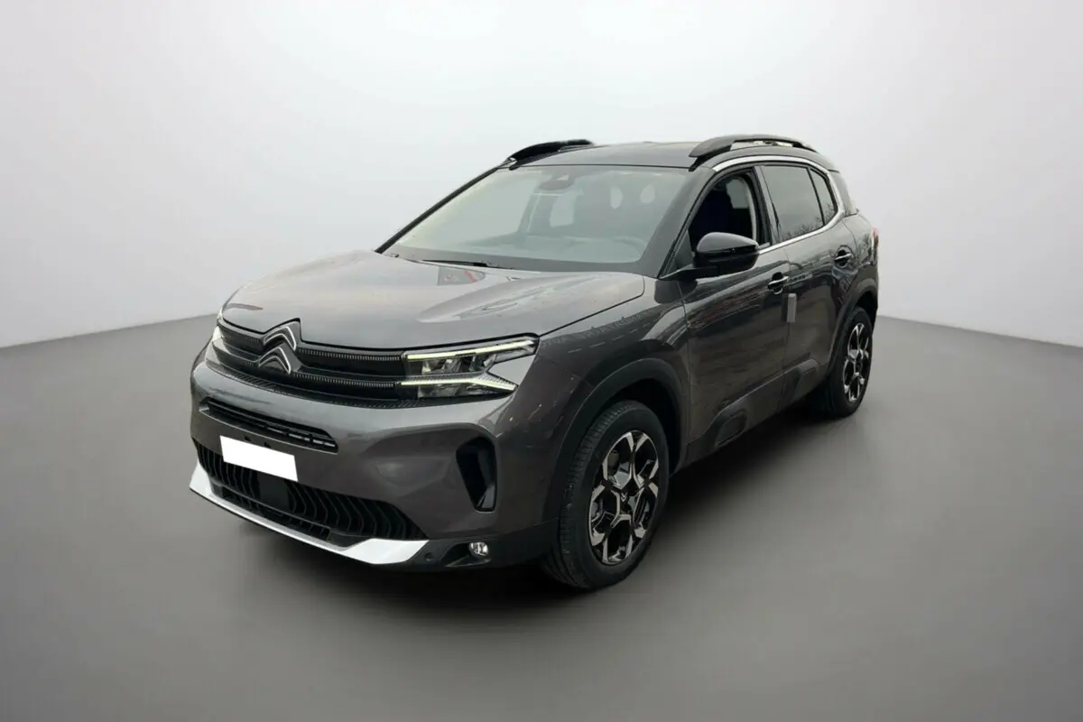 Citroën C5 Aircross Hybrid 145 2025 gris platinium avec toit noir, vue 3/4 avant côté droit mettant en valeur ses jantes distinctives.